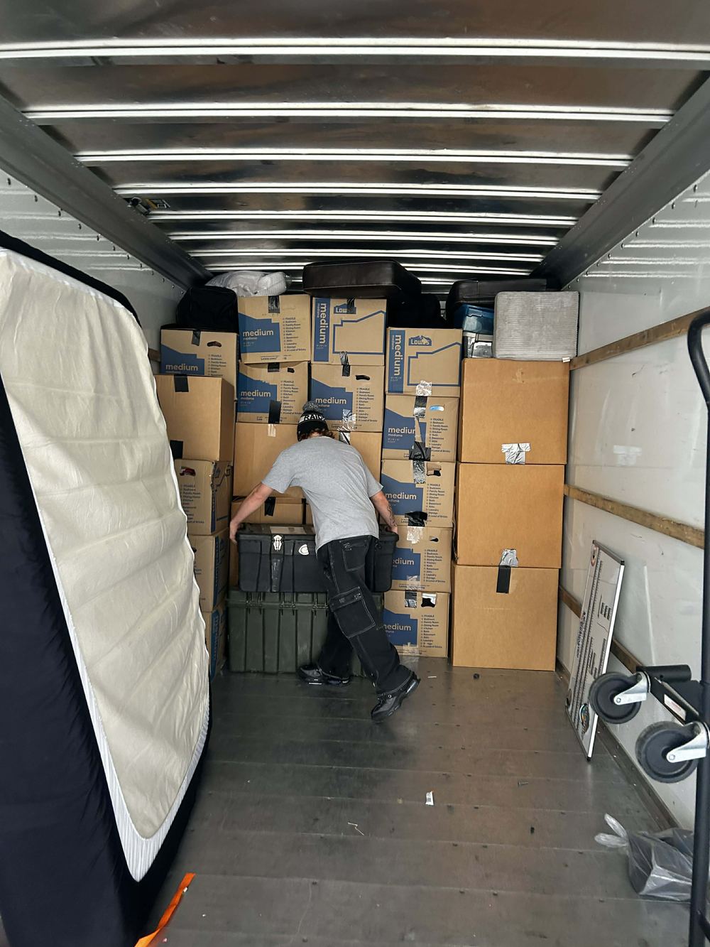 Citi Haulers crew member stacking boxes tight against the wall of a moving truck in Tulsa