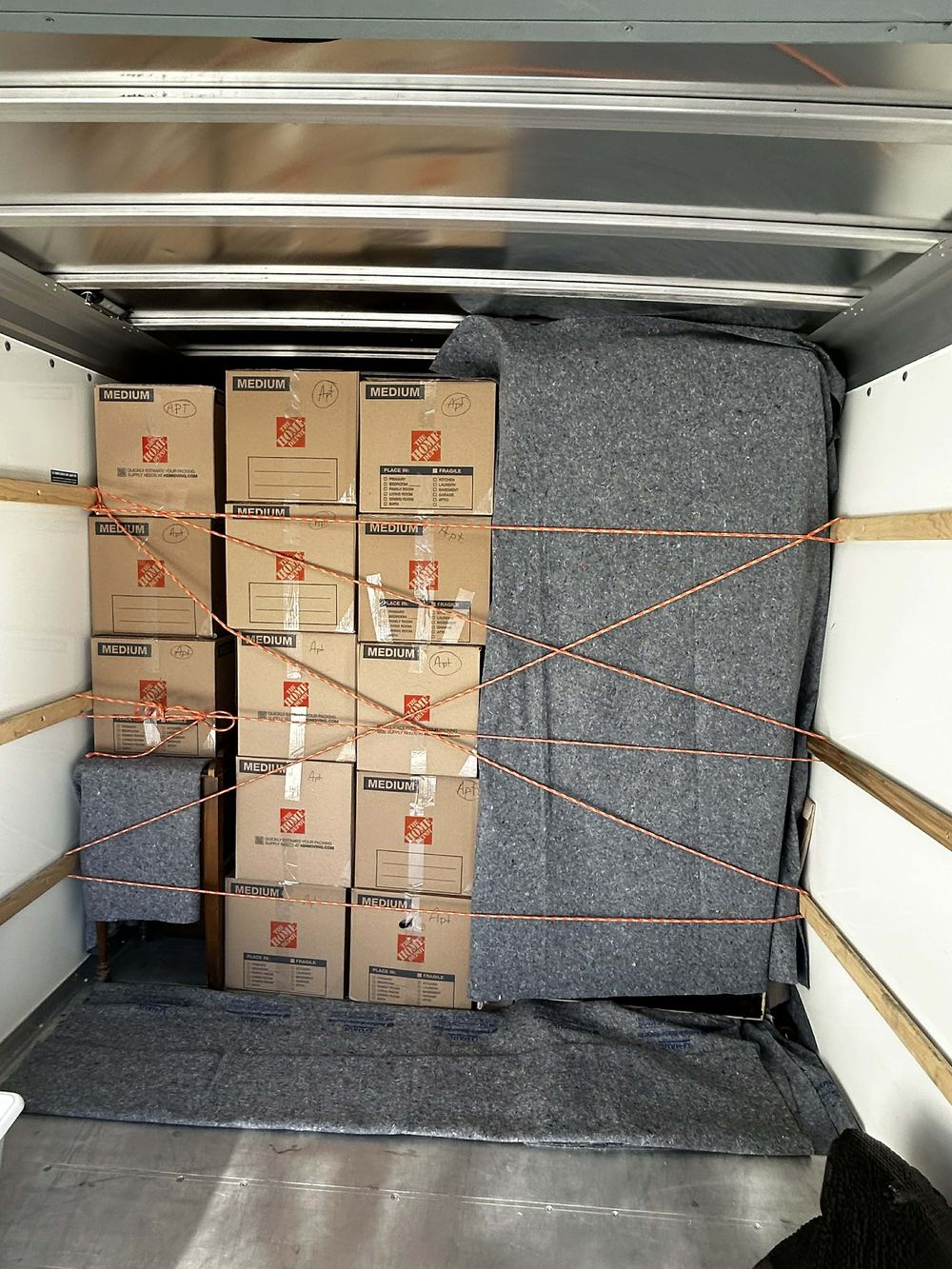 Boxes roped off in tiers and furniture pad-wrapped inside a rental truck loaded by Citi Haulers in Tulsa